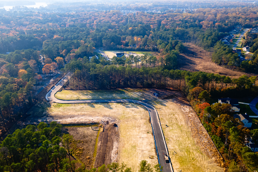 An aerial view of a winding road framed by a lush forest.