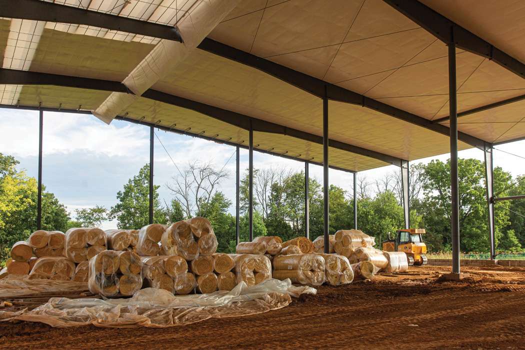 A large open-air structure holds stacks of bundled insulation.