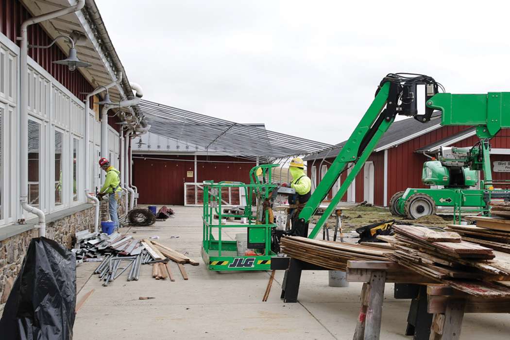 Construction workers use a lift to work on the exterior of a building.