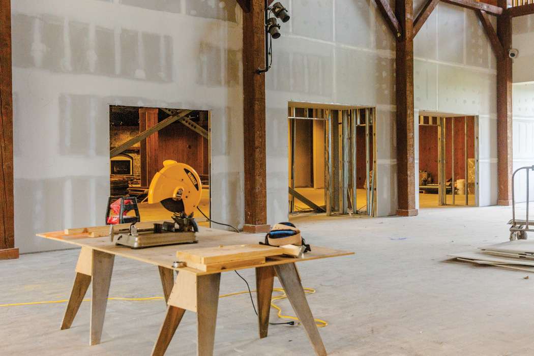 Yellow circular saw on a wooden table with dry wall frames in the background