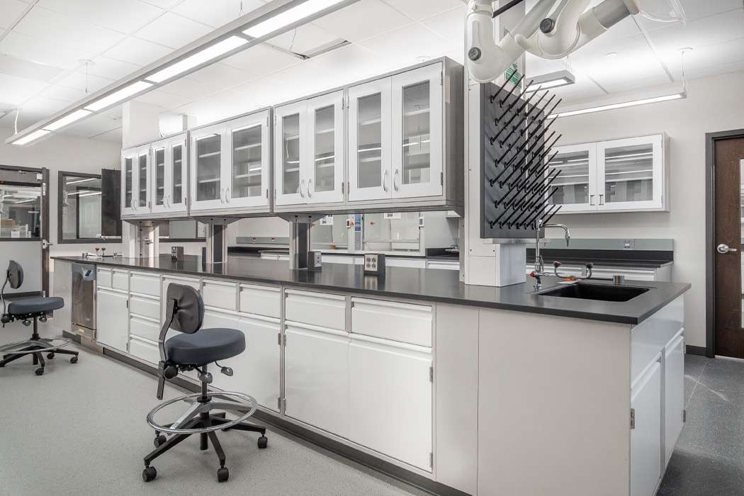 A modern, well-equipped laboratory features sleek white cabinetry and state-of-the-art equipment.