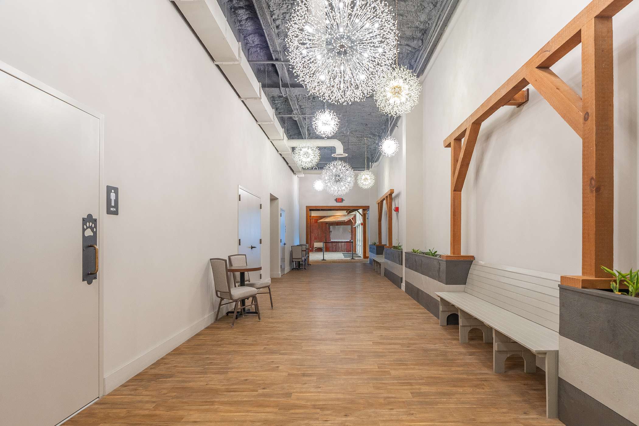 A long, bright hallway with light wood floors and minimalist decor.