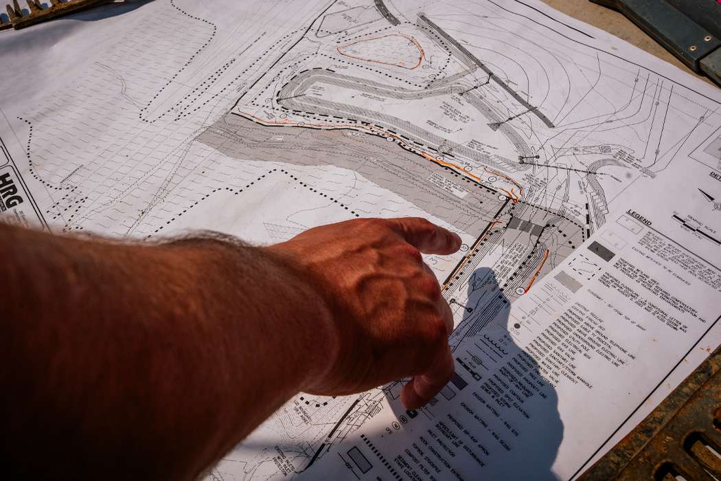 A person is pointing at a detailed blueprint